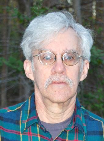 Person with short hair, glasses, and a blue plaid shirt