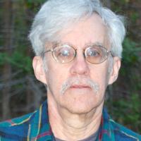 Man with grey hair and glasses