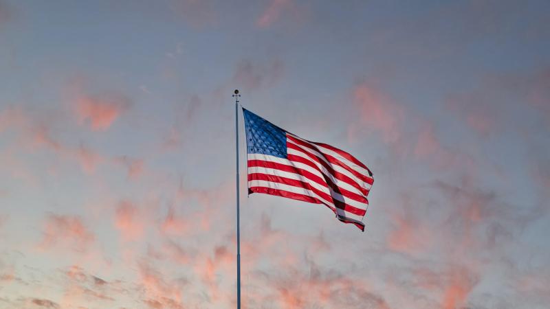 American flag with sunset sky in the background
